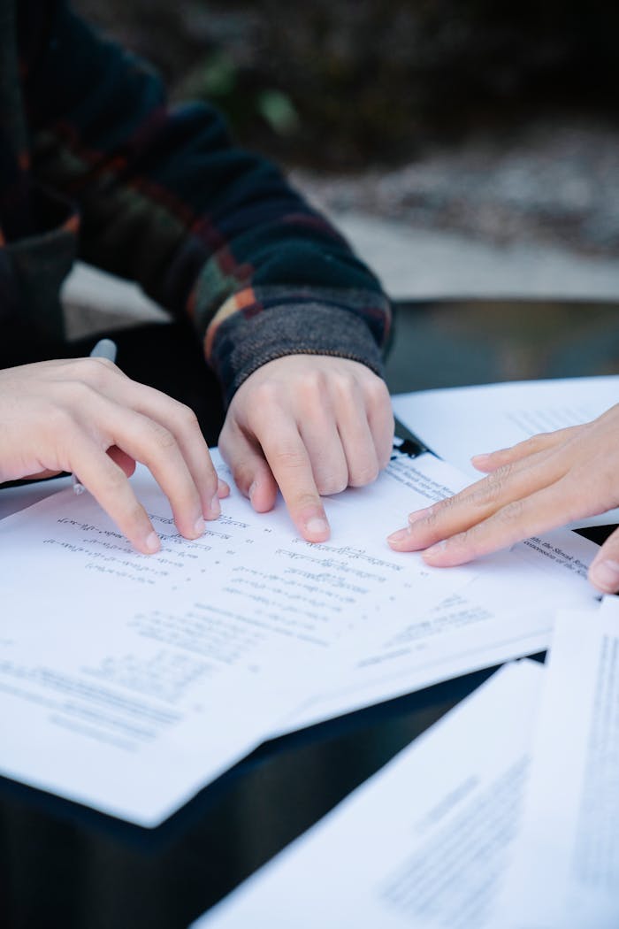 People working together with papers outside, focusing on teamwork and learning.