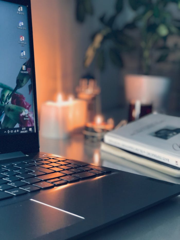 A warm and inviting workspace with a laptop, candles, and plants, ideal for productivity.